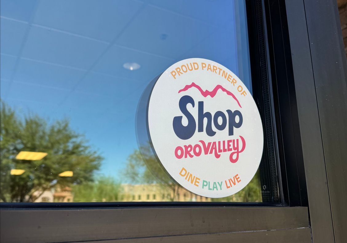 A Proud Partner of Shop Oro Valley window cling on a shop door