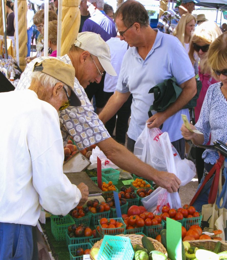 Shoppers choosing produce at a farmers market