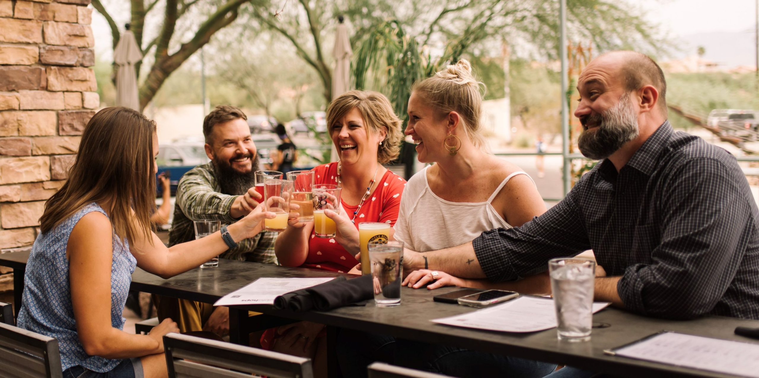 Friends raising their glasses at an outdoor restaurant table